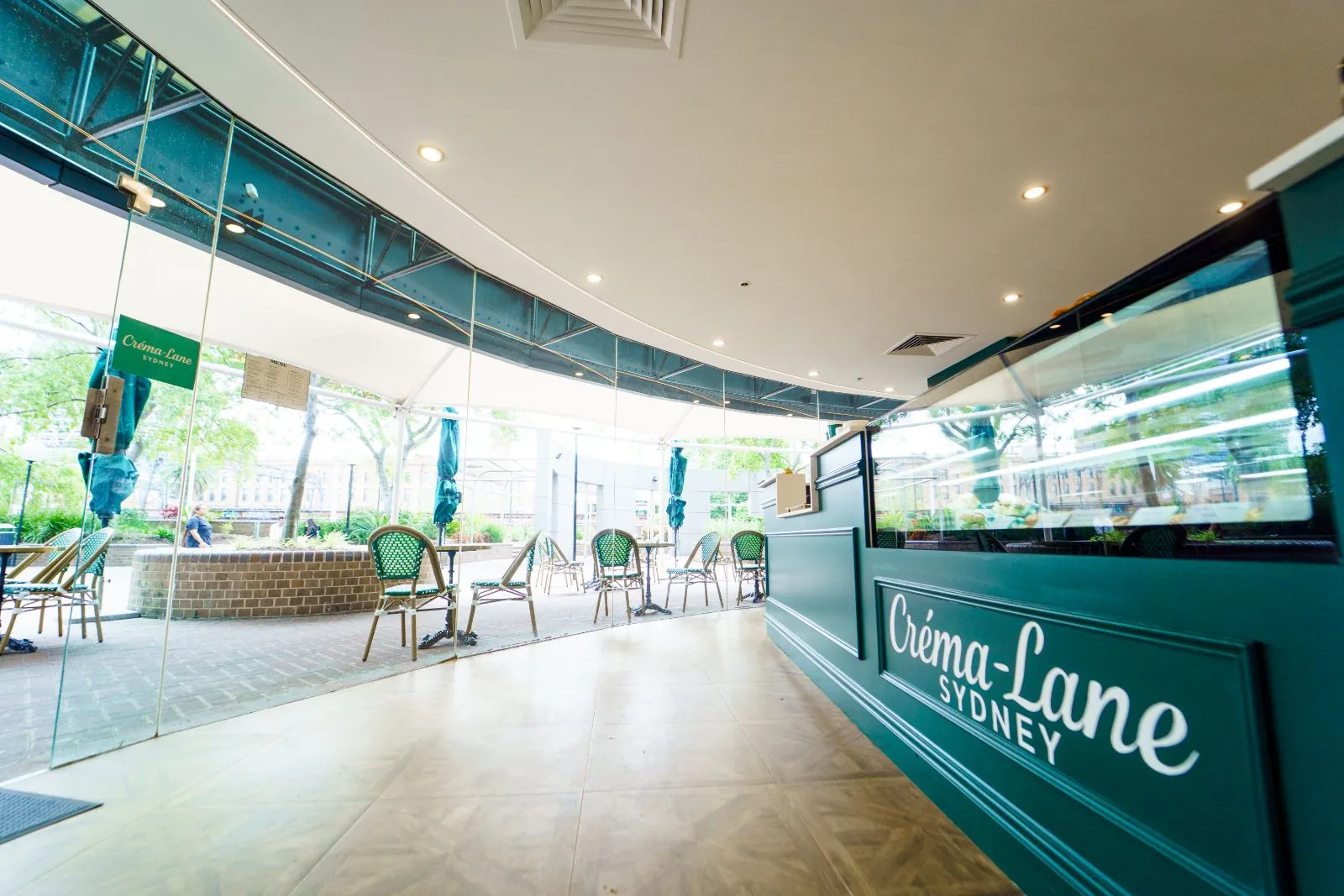 Créma-Lane's curved glass frontage and green counter